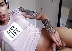 Inked shemale spreads her legs and strokes her stiff rod