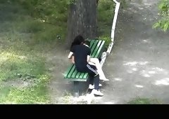 Teen couple making out in public park bench