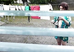 Neighbour in bathrobe out of pants and brassiere dries washing courtyard, neighbor watching out window