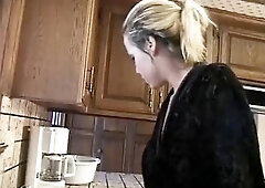 See this lewd blond disrobe off her red pants in the kitchen, bow over to tease, then have her taut cunt fisted and pounded hard on the counter until 