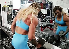 Muscled blonde woman is proudly showing her toned arms in the gym, while doing workout