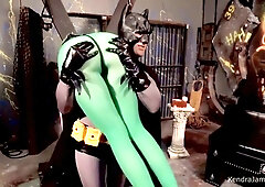 Kendra James bound and gagged in a BDSM dungeon with a Batman-costumed dominator