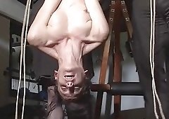 Dominant older couple tightly suspends their slave girl with rope