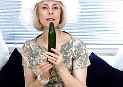 Older housewife bangs a cucumber