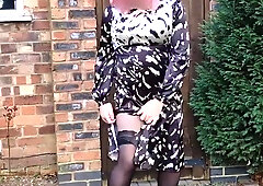 Rosy haired crossdresser in spectacular back satin dres