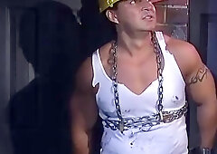 TIED MUSCLE JOCKS - Beefy construction employee is tied up with chains