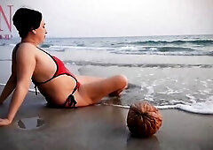 Good lady at lonely nudist beach. Red swimsuit. Red bikini. Coconut