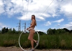 A daring Russian teen with a big ass puts on a risky public show, spinning a hoop in a field while naked, and performing a footjob, all captured on he