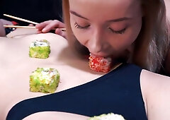 Bound man receives sushi on his body and foot worship in a dim BDSM dungeon