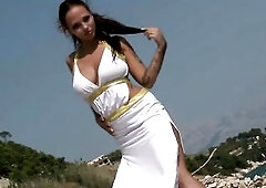 See this pretty brunette hair angel tease and undress off her white suit in a stunning outdoor setting. This babe positions seductively in nature'