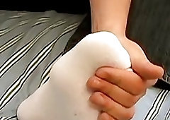 Asian twink teases with his soft feet and jerks off