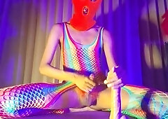 Sissy in an orange balaclava pokes herself with a dildo while dressed in pantyhose