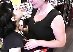Breasty aged café owner with glasses and pearls seduces a curvy darksome haired customer among the bookshelves. Tit sucking, twat licking in ebony la