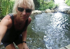 Alexa Cosmic trans doll swimming in font near waterfall dressed in cut-offs and t-tee-shirt...