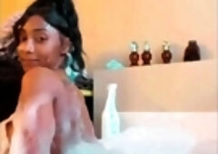 Ebony seductress poses and plays with herself in the bathtub